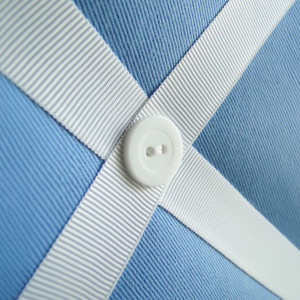 Close up of white button detail on the blue fabric memo board